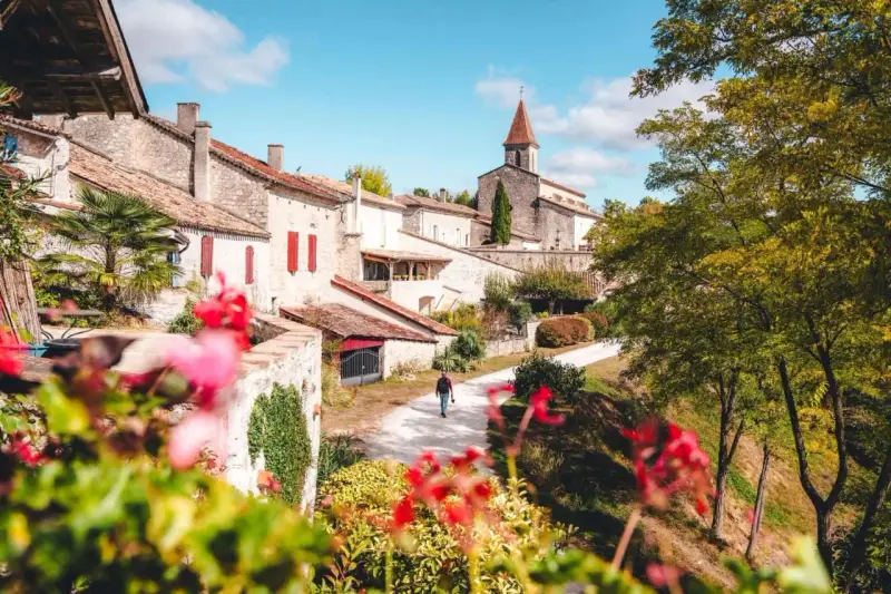 Un homme se promène dans un village pittoresque du Tarn-et-Garonne, une belle activité en plein air.